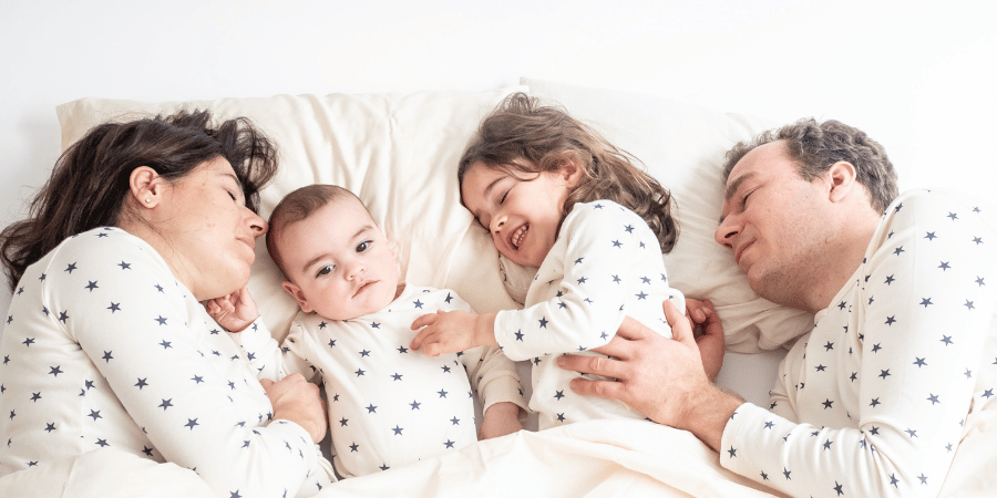 Parents massaging their children in bed